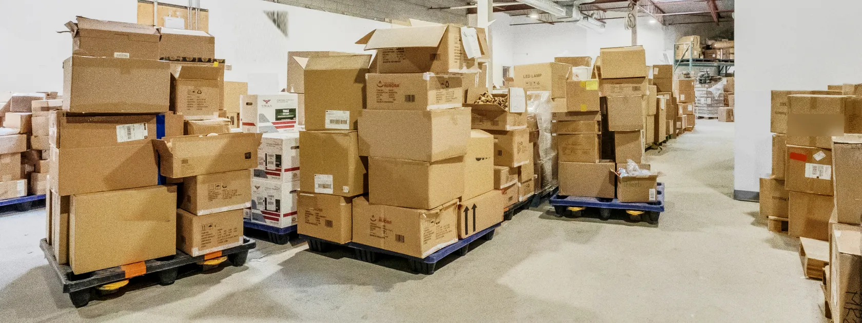 Cartons stacked on blue pallets, staged on the open floor of the Prep Buddies warehouse